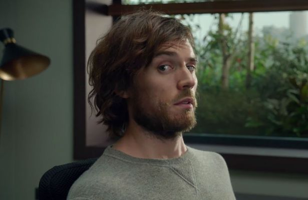 a still from the film "me before you" - an unkempt white male with long hair and a beard is looking to the side and sitting in a wheelchair
